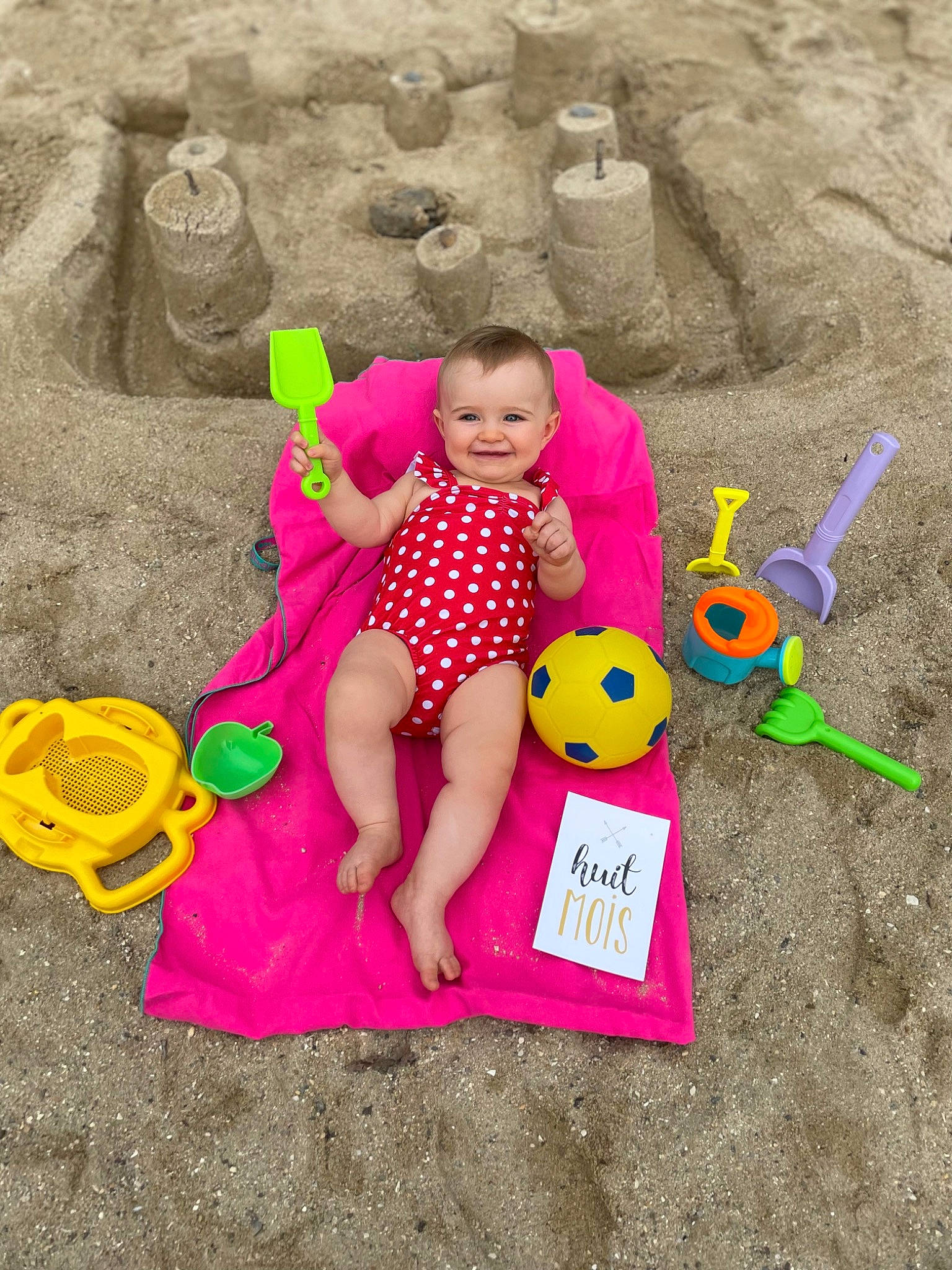 Louanne a rejoint le concours — aidez-le/la à gagner de superbes lots ! adaptation, baby, baby_products, baby_toddler_clothing, child, facial_expression, fun, grass, happy, hat, joy, leisure, magenta, people_in_nature, person, play, product, recreation, sand, sitting