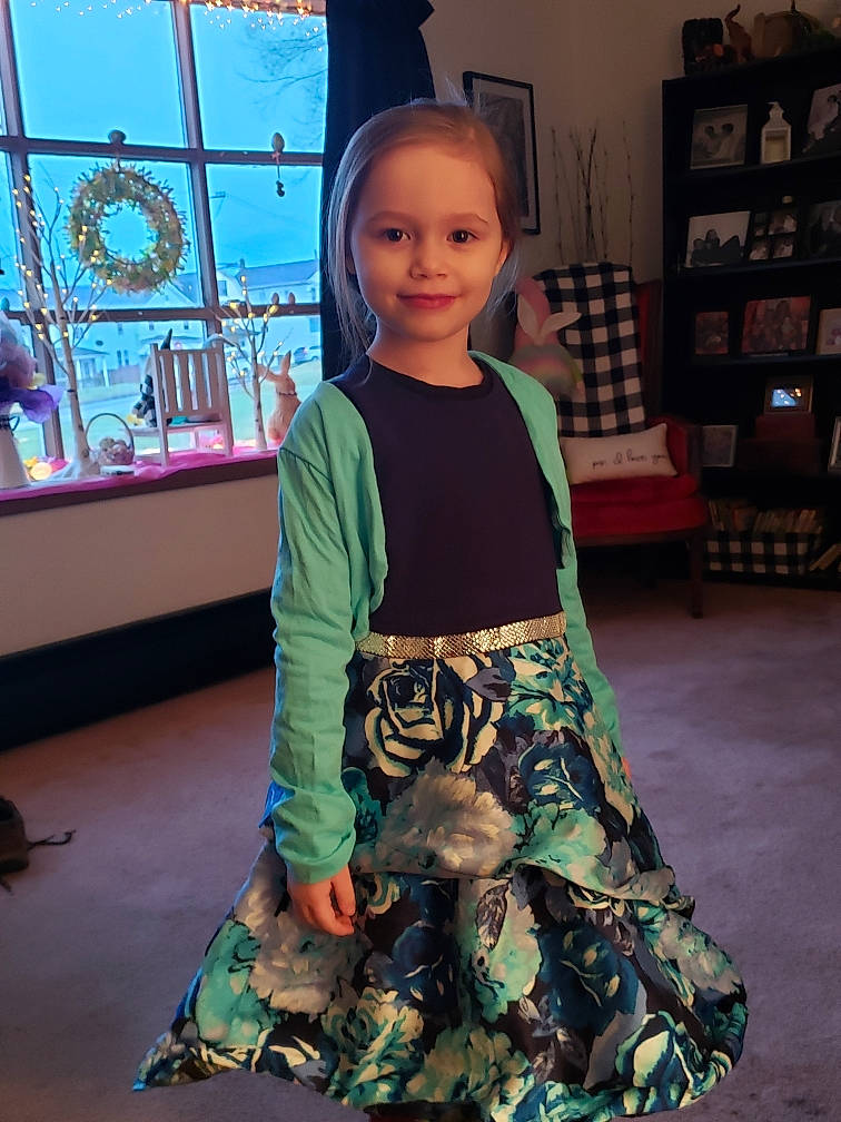 Remington is registered to the contest to win money with this photo: baby_toddler_clothing, child, dress, eye, fashion_design, flooring, fun, hairstyle, happy, human_body, joint, joy, pattern, person, shelf, sitting, sleeve, smile, standing, t_shirt