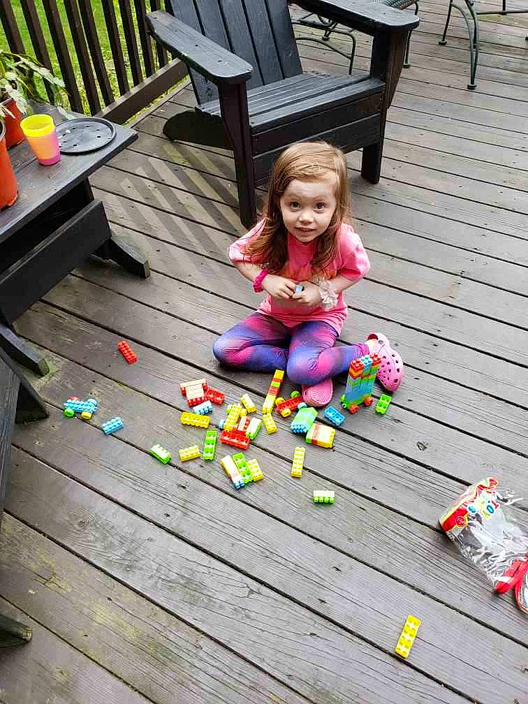 Killian joined the competition — help win amazing prizes! bench, child, flooring, fun, grass, hardwood, leisure, outdoor_bench, outdoor_furniture, pattern, person, plant, play, recreation, sitting, smile, sunglasses, toddler, toy, tree