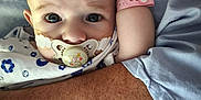 Martin a rejoint le concours — aidez-le/la à gagner de superbes lots ! baby, pacifier, hospital_wristband, arm, adult, clothing, person, holding, closeup, face, skin, hospital_gown, blue, pink, infant, child, care, comfort, expression, portrait