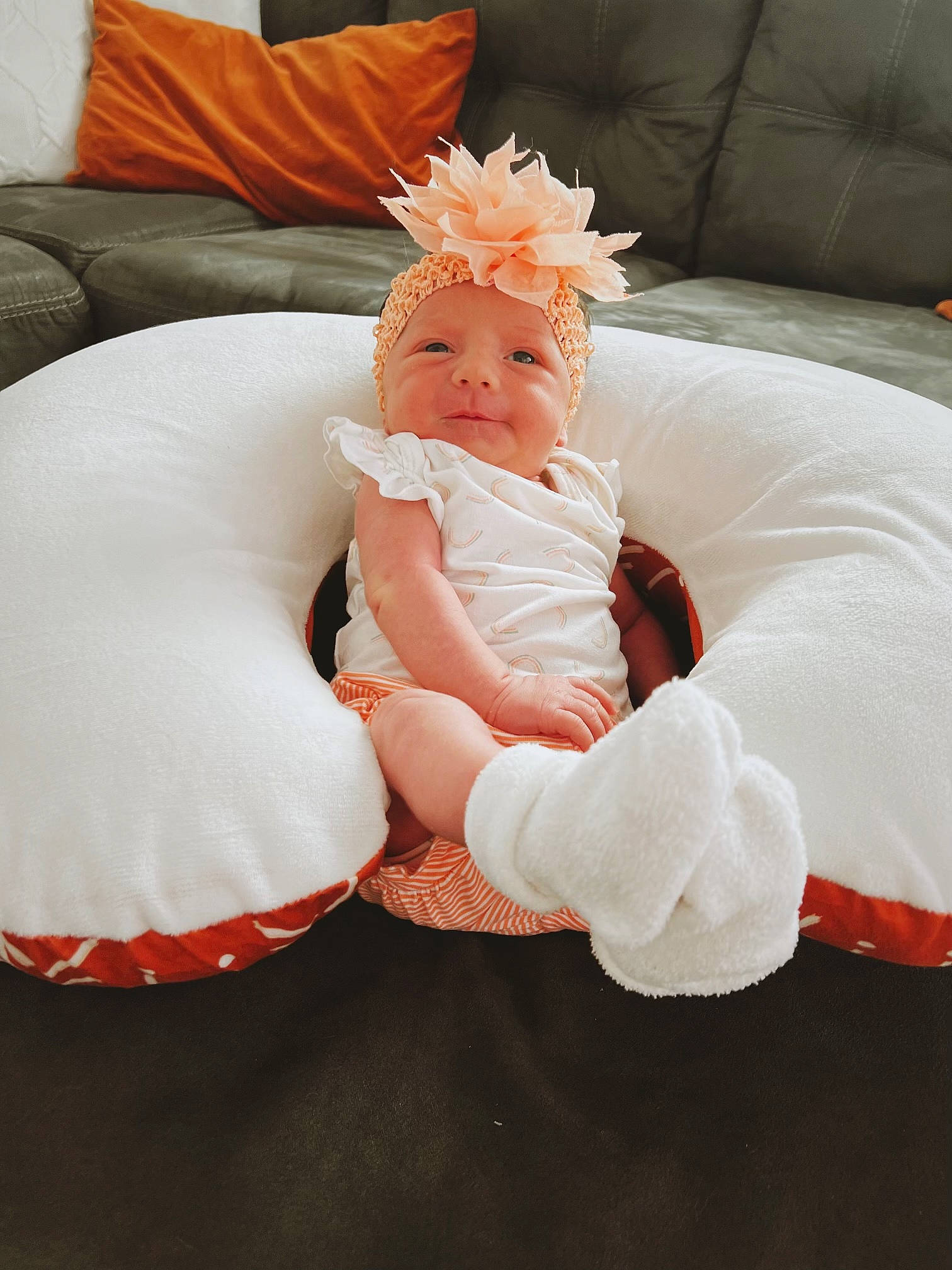 Elsie joined the competition — help win amazing prizes! baby, baby_toddler_clothing, comfort, costume_hat, couch, dress, eye, furniture, happy, hat, head, headwear, human_body, leg, orange, peach, person, petal, pillow, pink