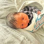 Jonahh is registered to the contest to win money with this photo: newborn, baby, infant, wrapped, blanket, hospital, soft_texture, lying_down, face, head, person, clothing, sleepwear, cute, portrait, indoors, skin, young_child, human, resting