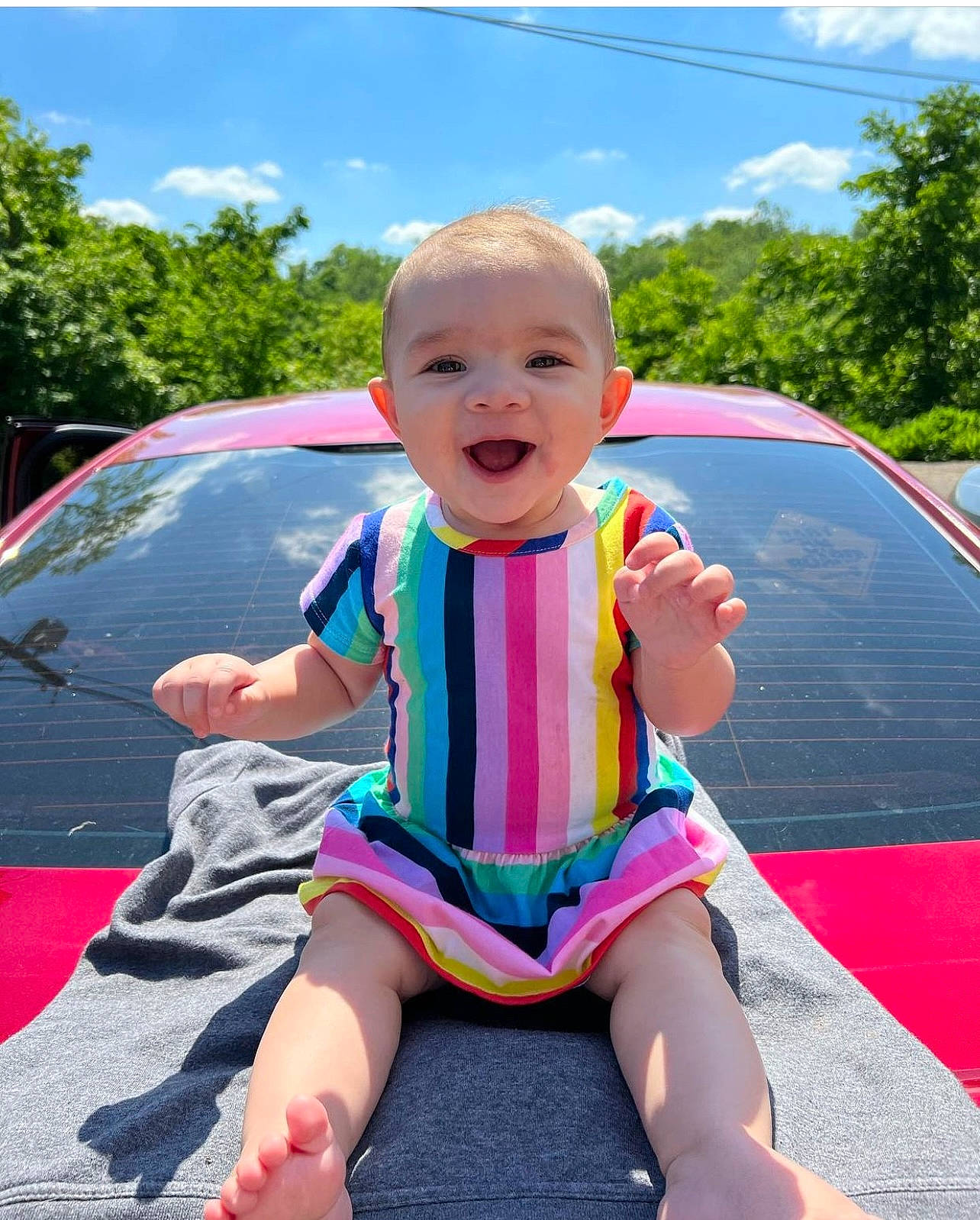 Malaysia is registered to the contest to win money with this photo: automotive_exterior, baby_toddler_clothing, bumper, car, cloud, fun, grass, happy, hood, leisure, motor_vehicle, person, pink, recreation, sky, smile, summer, toddler, tree, vehicle