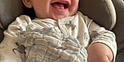 Kairo is registered to the contest to win money with this photo: baby, blanket, child, closeup, clothing, comfort, cushion, cute, face, hand, happy, indoors, infant, portrait, sitting, skin, smiling, soft, texture, young