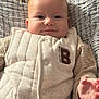 baby, infant, smile, face, hand, clothing, vest, quilted, blanket, bed, soft_light, cute, portrait, closeup, child, young, warm, texture, indoor, cozy