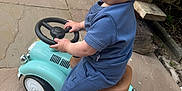 Harbi joined the competition — help win amazing prizes! toddler, child, toy_car, blue_clothing, outdoor, curly_hair, sandals, pavement, bench, greenery, side_view, small_vehicle, play, person, casual, daylight, cute, fun, park, nature