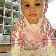 Kahïl participe au concours pour gagner de l'argent avec cette photo : toddler, child, crawling, pink_jersey, cap, white_clothing, indoor, living_room, plants, shelf, decor, curious, portrait, young_child, floor, hands, eyes, casual, home, cute