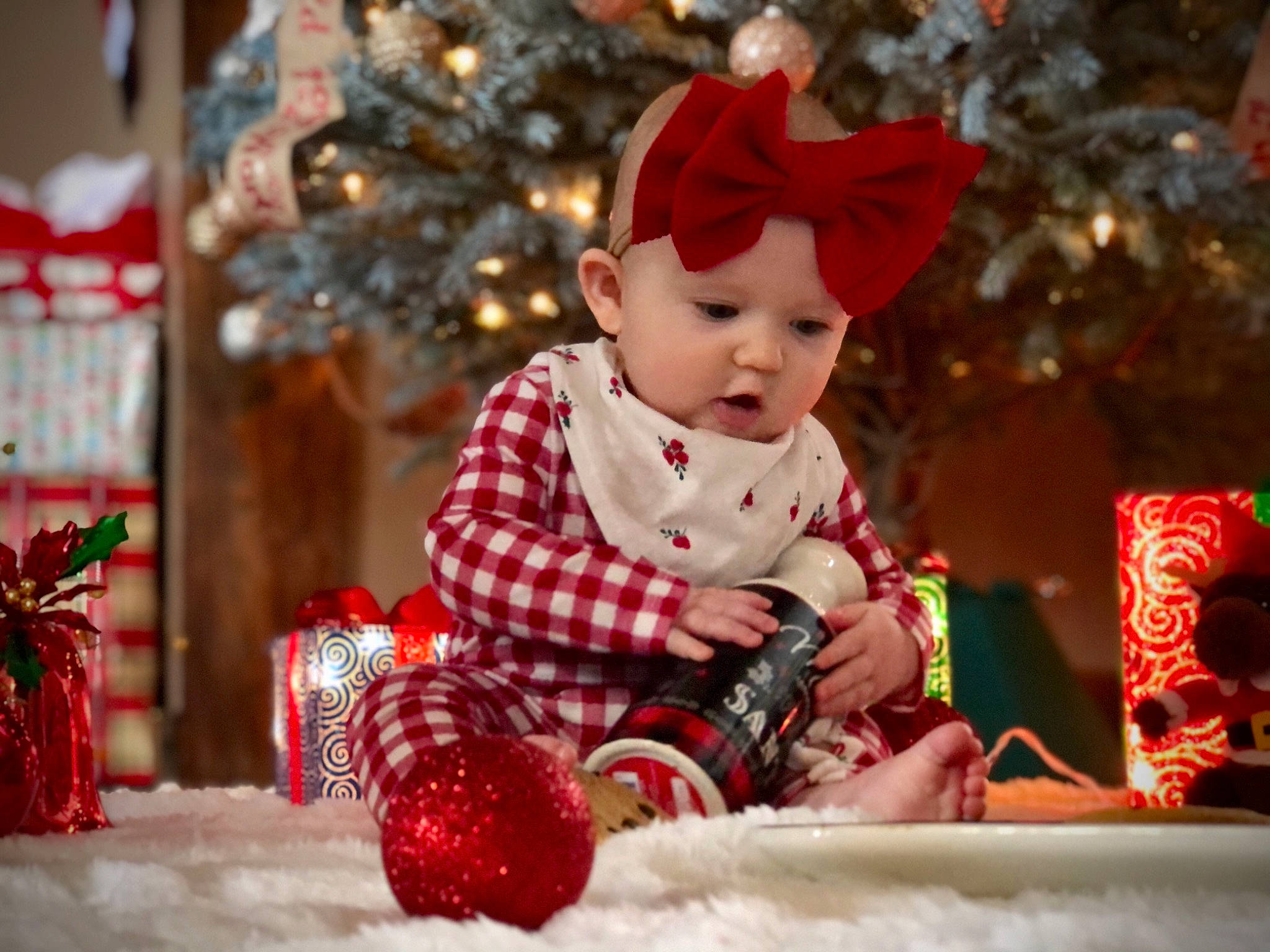 Graycen is registered to the contest to win money with this photo: baby, baby_toddler_clothing, carmine, child, christmas, christmas_decoration, christmas_eve, christmas_ornament, christmas_tree, costume_accessory, event, fictional_character, headwear, holiday, interior_design, nose, ornament, person, red, toddler