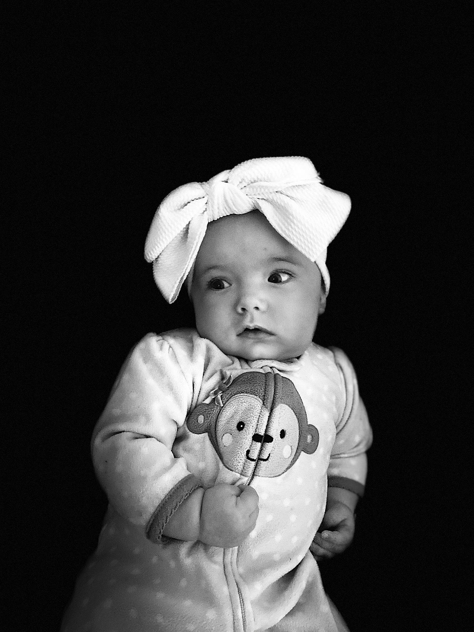 Aria is registered to the contest to win money with this photo: baby, baby_products, baby_toddler_clothing, bonnet, cheek, child, costume_accessory, flash_photography, headwear, human, monochrome, person, portrait, portrait_photography, skin, sleeve, toddler