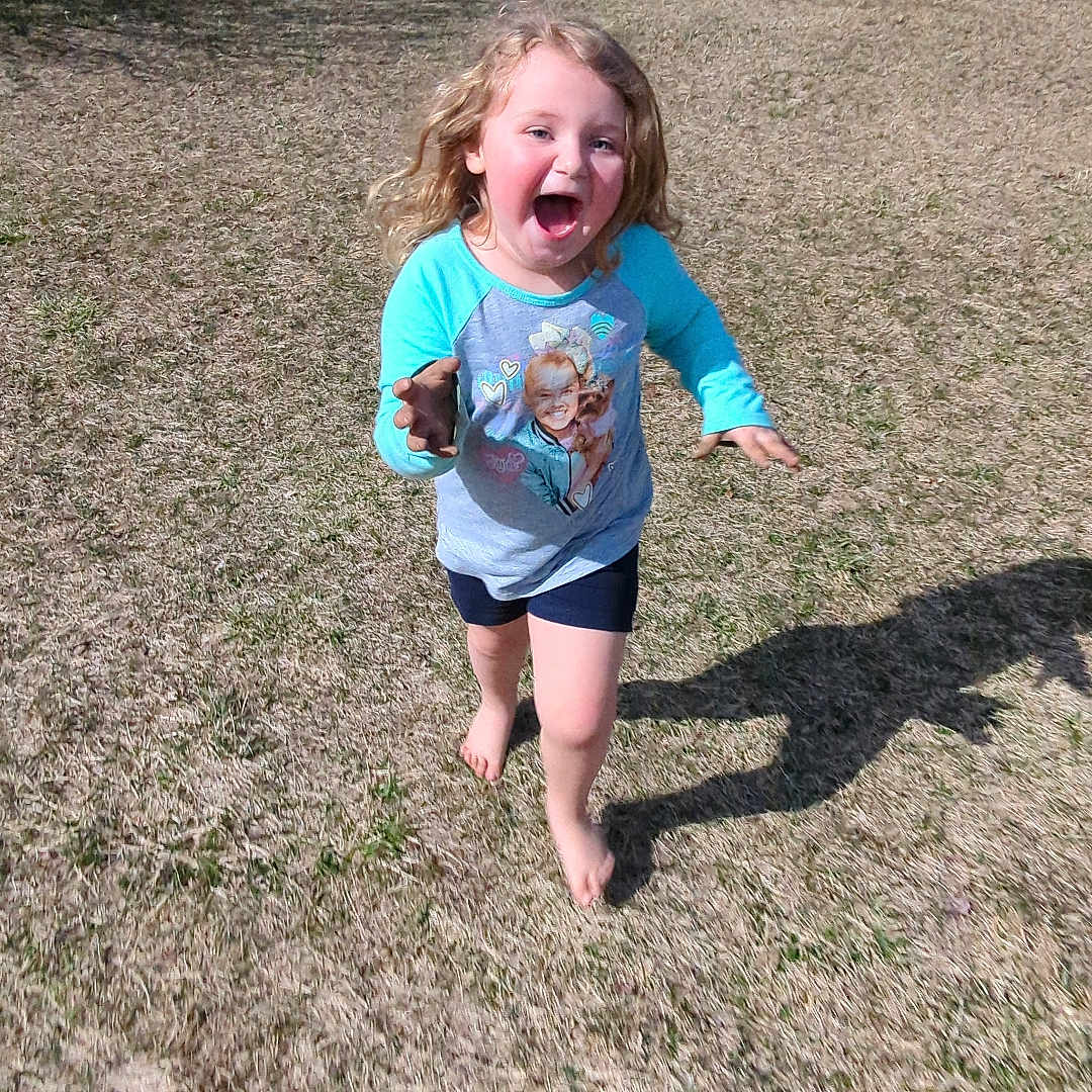 Rylee is registered to the contest to win money with this photo: backyard, child, clothing, face, female, girl, grass, head, lawn, nature, outdoors, park, person, photography, plant, portrait, shorts, summer, t_shirt, yard