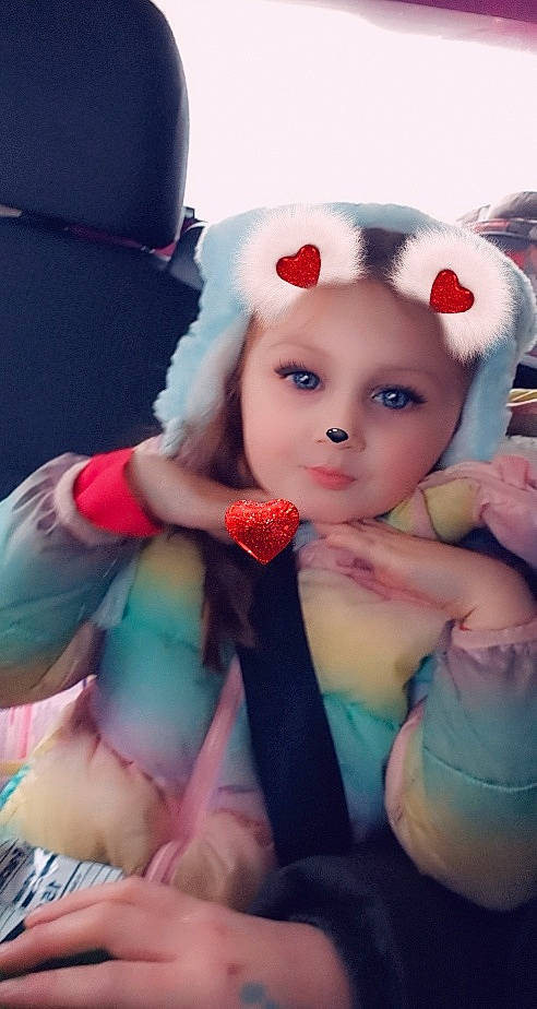 Christine is registered to the contest to win money with this photo: baby_toddler_clothing, brown_hair, cap, child, doll, dress, eyelash, face, fashion_accessory, fawn, fur, headband, headwear, lip, nail, person, pink, plush, skin, stuffed_toy