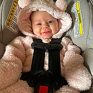 Willow joined the competition — help win amazing prizes! baby, infant, car_seat, pink, fluffy, hood, smiling, face, child, seatbelt, safety, cute, apparel, clothing, young_child, indoors, portrait, expression, happy, cozy