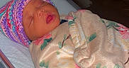 Nayloni is registered to the contest to win money with this photo: newborn, baby, infant, sleeping, blanket, hat, hospital, bassinet, face, person, cute, child, wrapped, cozy, indoors, resting, soft, floral, knitted, peaceful