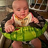 baby, baby_walker, bib, child, clothing, expression, face, floor, hand, home, indoor, infant, person, relaxed, seat, sitting, toddler, toy, walker, wooden_floor