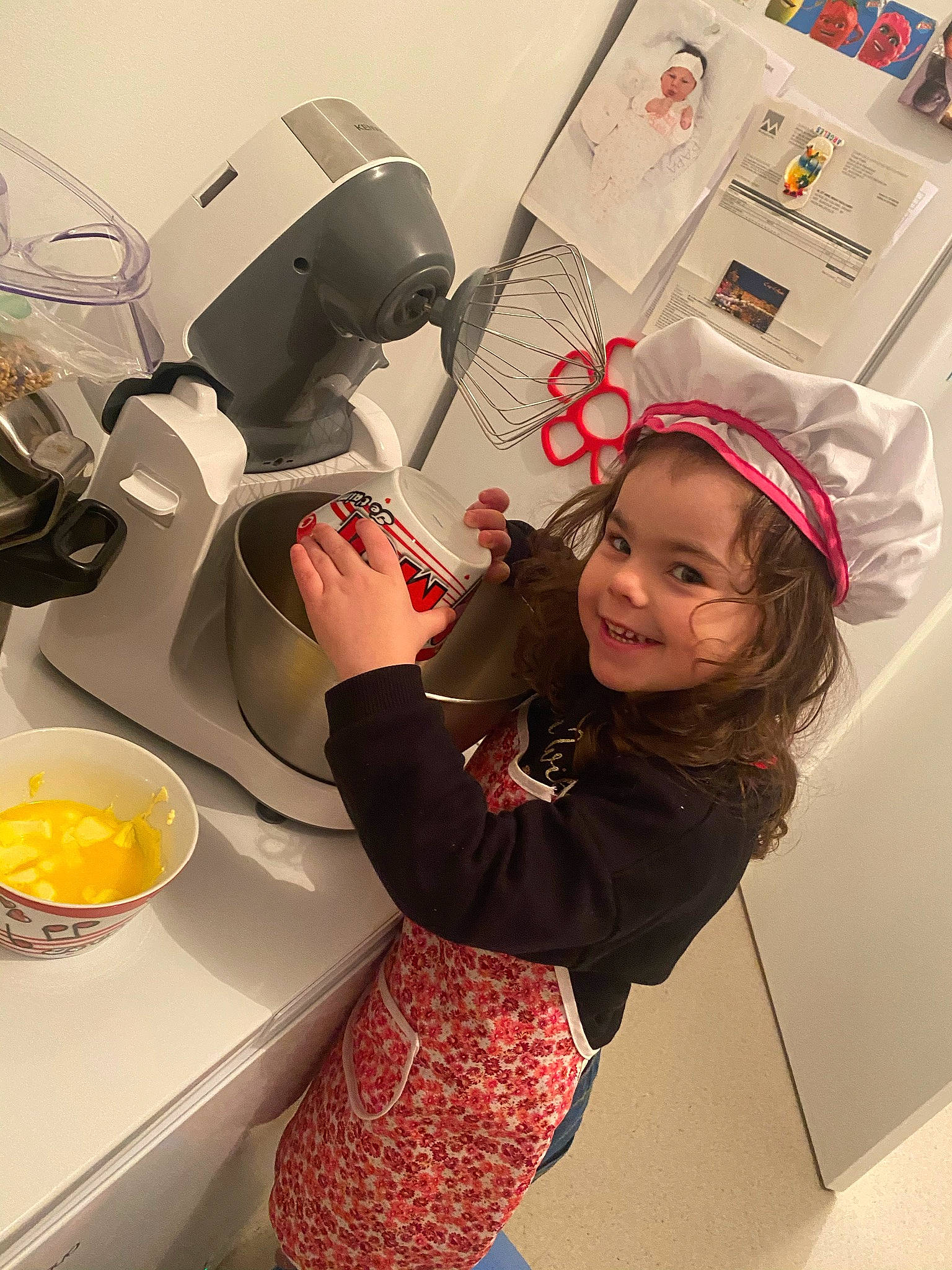 Malia participe au concours pour gagner de l'argent avec cette photo : automotive_design, bowl, carmine, child, cooking, flooring, fun, happy, hat, home_appliance, joy, kitchen, mixing_bowl, person, personal_protective_equipment, plate, room, serveware, smile, t_shirt