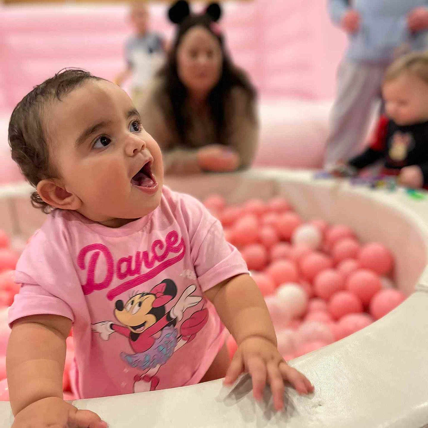 Elvira-June joined the competition — help win amazing prizes! baby, ball_pit, balls, blurred_background, casual_clothing, child, dance, face, fun, hand, happy, indoor, minnie_mouse, person, pink, playground, shirt, smiling, toddler, toys