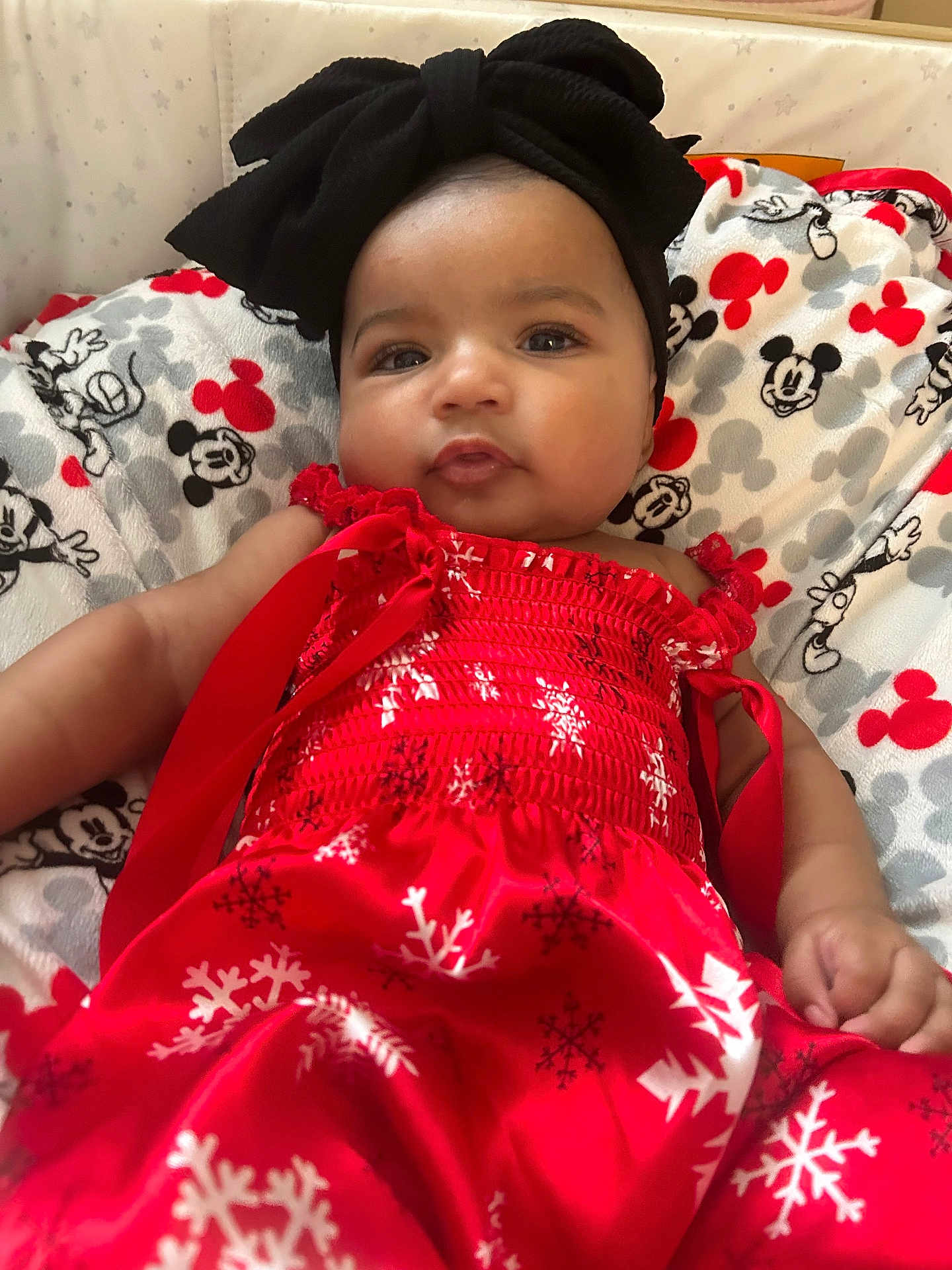 Genesis joined the competition — help win amazing prizes! baby, child, infant, red_dress, black_headband, mickey_mouse, blanket, pattern, snowflake, cute, portrait, indoors, soft_lighting, smile, face, hand, relaxing, holiday_theme, adorable, young
