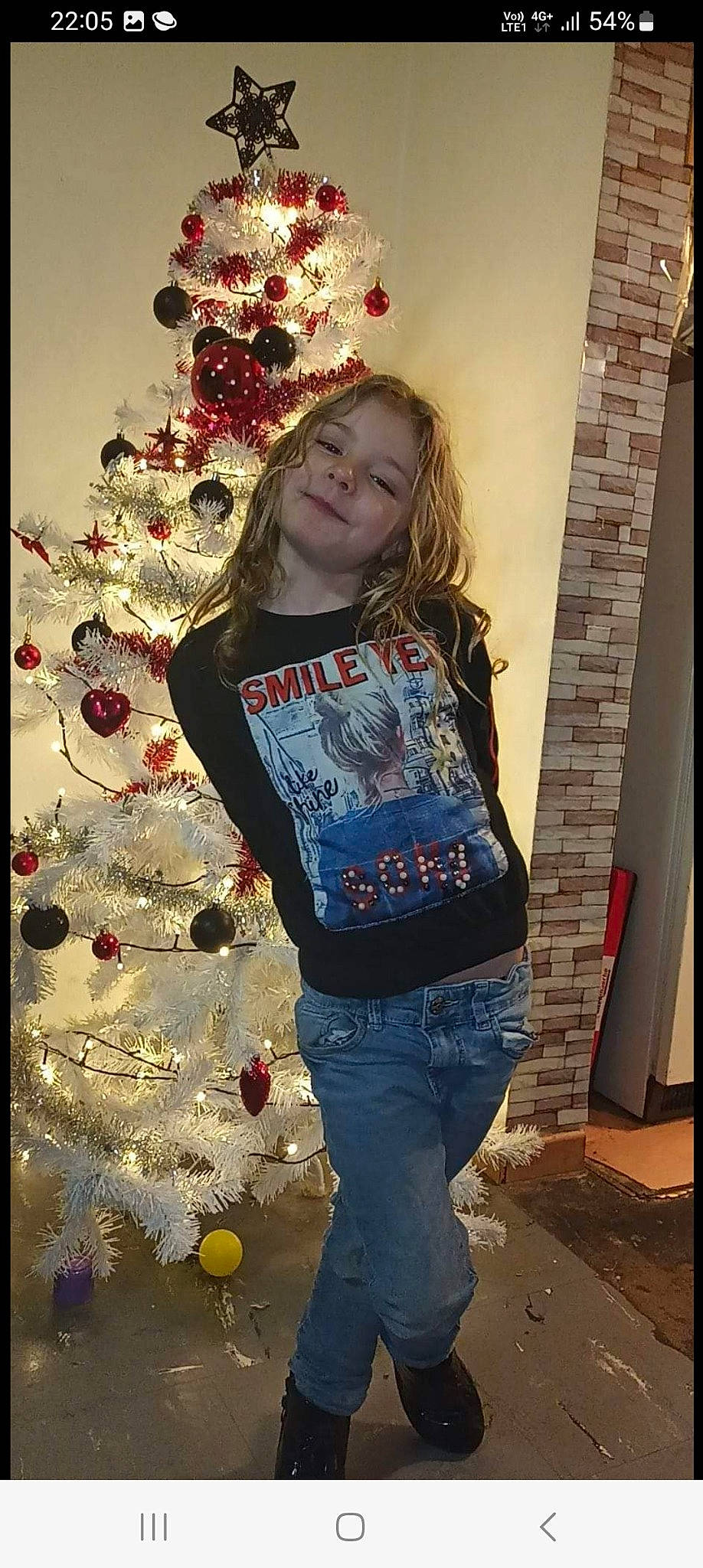 Emilie participe au concours pour gagner de l'argent avec cette photo : christmas, christmas_decoration, christmas_ornament, christmas_tree, event, happy, holiday, holiday_ornament, human, jeans, joy, ornament, person, red, sleeve, standing, t_shirt, tree, waist, white