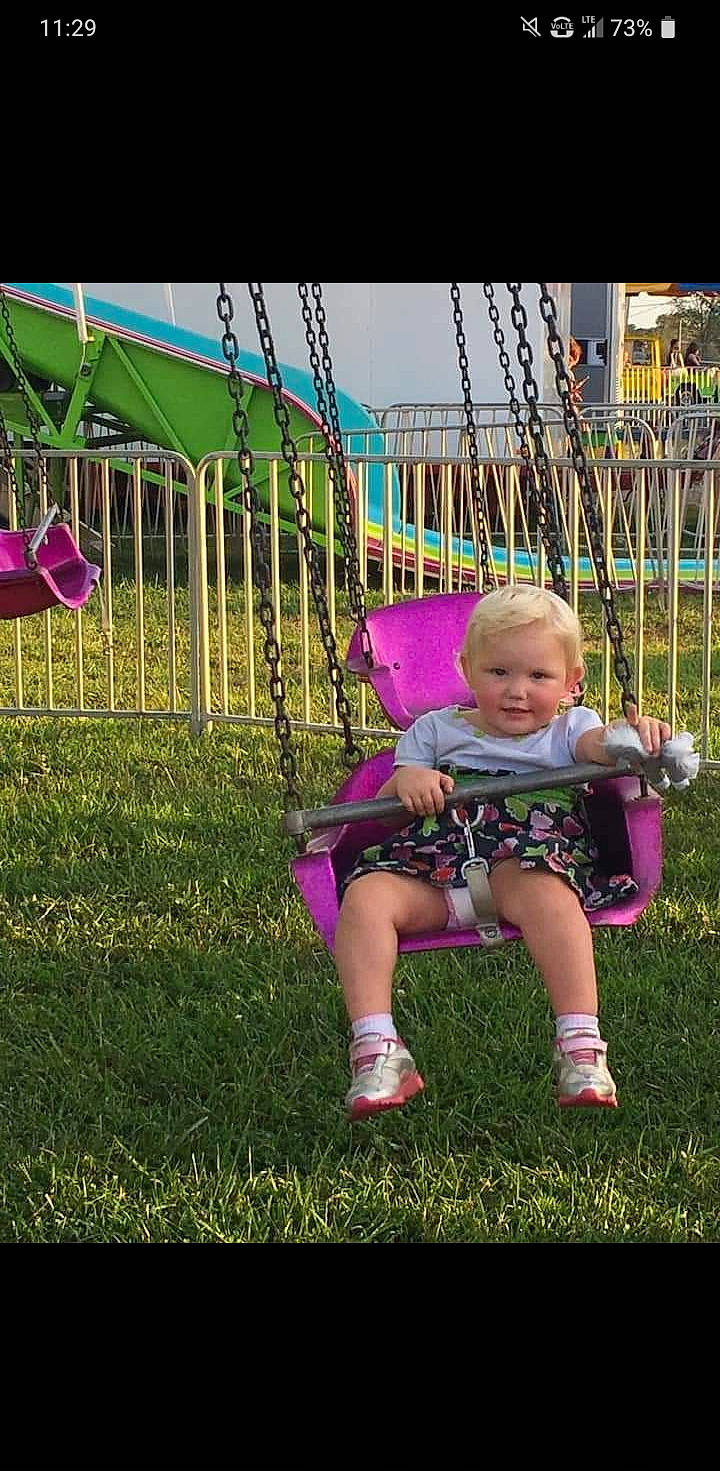 Aubrey joined the competition — help win amazing prizes! child, fun, grass, happy, lawn, magenta, outdoor_play_equipment, person, plant, play, playground, public_space, sitting, smile, swing, toddler, tree, yard
