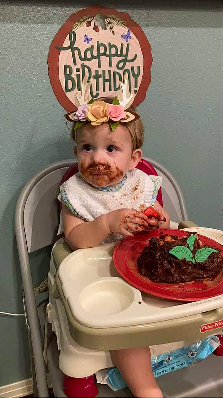 Rayne is registered to the contest to win money with this photo: baby_toddler_clothing, birthday, birthday_cake, cake, cake_decorating, chair, cuisine, dish, food, food_craving, happy, icing, ingredient, person, pink, plate, recipe, smile, sweetness, tableware