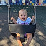 baby, swing, playground, child, smiling, happy, outdoor, sunlight, shadow, mosaic_wall, chains, feet, shirt, shorts, seat, play, infant, daylight, fun, park