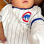 Enzo is registered to the contest to win money with this photo: apparel, baby, baseball_jersey, casual, chicago_cubs, child, clothing, cute, face, hand, human, indoor, infant, looking_away, nail_polish, person, portrait, sitting, striped, young