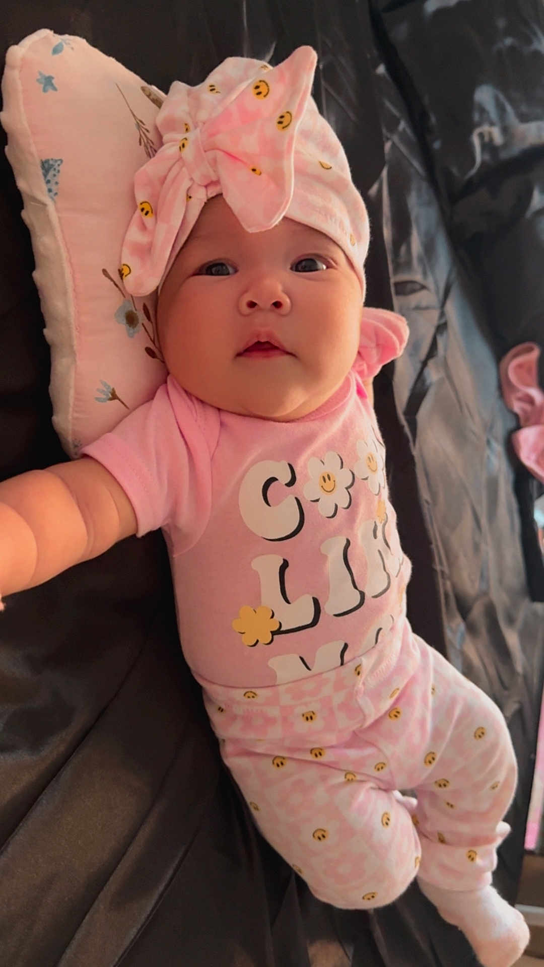 Denayt joined the competition — help win amazing prizes! baby, child, chubby_cheeks, couch, cozy, cute, fabric, face, headband, indoors, infant, lying_down, patterned_clothing, person, pillow, pink_clothing, portrait, reaching, smileys, soft_toys