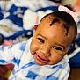 Jey-ïqa is registered to the contest to win money with this photo: baby, child, smiling, face, pink_bow, curly_hair, blue_and_white, checkered_clothing, cute, portrait, indoor, person, happy, cozy, closeup, head, infant, young_child, soft_focus, warm