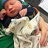 Jaxon joined the competition — help win amazing prizes! newborn, baby, infant, hat, blue_hat, blanket, dinosaur_pattern, hand, sleeping, face, person, clothing, indoor, resting, cozy, soft, cute, child, human, portrait