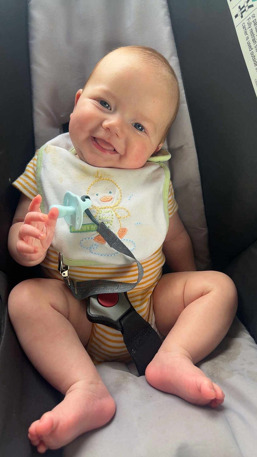 Hezekiah is registered to the contest to win money with this photo: baby, infant, smiling, car_seat, bib, pacifier, onesie, barefoot, cute, happy, child, seatbelt, striped_clothing, chubby_cheeks, indoor, closeup, person, baby_toys, comfort, portrait