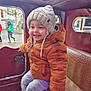 Louis a rejoint le concours — aidez-le/la à gagner de superbes lots ! casual, child, clothing, happy, hat, jacket, knit_hat, orange_jacket, outdoor, people, portrait, rainy_day, seat, smile, street, toddler, umbrella, vintage_vehicle, warm_clothing, window