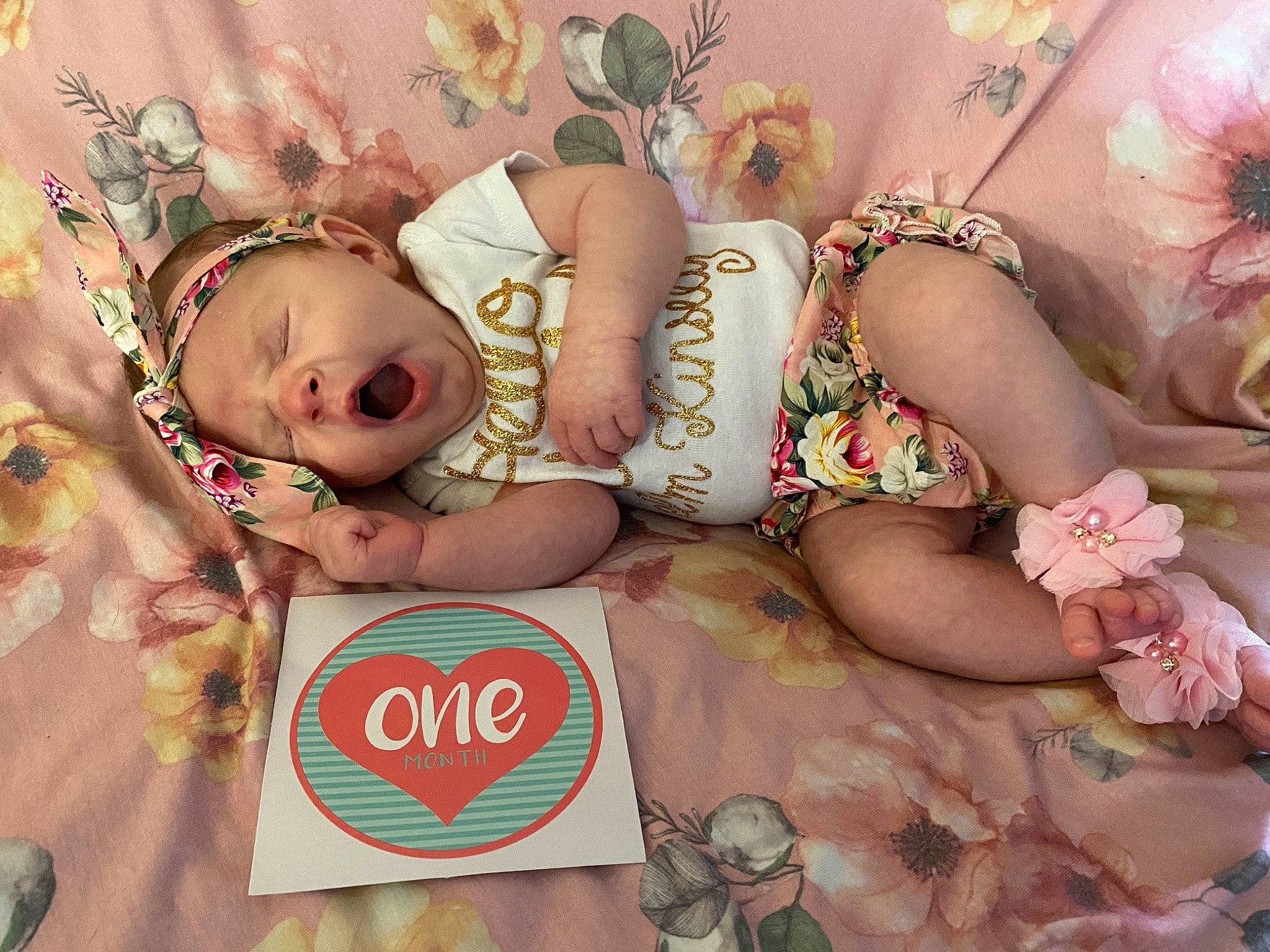 Kinsley joined the competition — help win amazing prizes! baby, baby_toddler_clothing, child, event, fashion_accessory, flower_arranging, font, happy, headgear, headpiece, human_leg, jewellery, pattern, peach, person, petal, pink, rose, skin, thigh