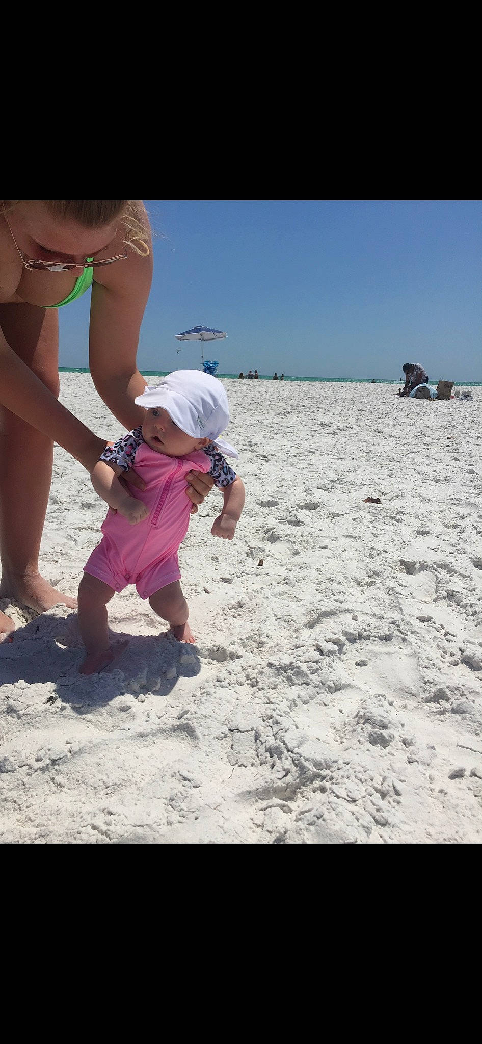Kinsley is registered to the contest to win money with this photo: baby, baseball_cap, beach, body_of_water, child, fun, happy, hat, headwear, landscape, leisure, people_in_nature, people_on_beach, person, recreation, sand, shorts, sky, soil, sun_hat