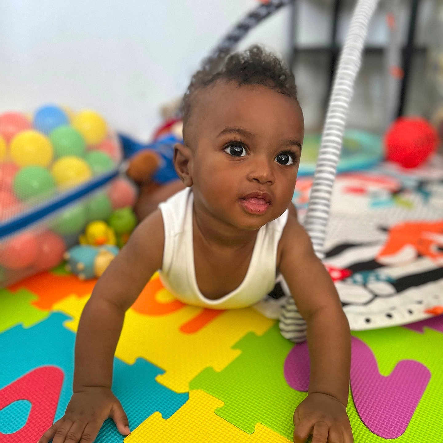 Kaamil is registered to the contest to win money with this photo: baby, bright, child, clothing, colorful, crawling, curious, cute, face, floor, hands, happy, indoor, infant, person, playgym, playmat, smiling, toys, young_child