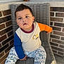 Adrian is registered to the contest to win money with this photo: boy, brick_wall, casual, chair, child, colorful_clothing, curious, dinosaur_print, expression, face, indoors, long_sleeve_shirt, natural_light, pajamas, portrait, sitting, socks, toddler, woven_chair, young_child