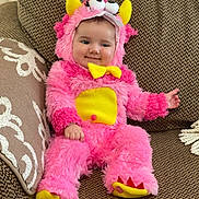 Elena joined the competition — help win amazing prizes! baby, child, costume, pink, yellow, monster, plush, furry, smile, couch, indoor, cute, face, infant, seated, clothing, playful, soft, happy, home