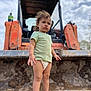 Elena joined the competition — help win amazing prizes! toddler, child, barefoot, diaper, green_shirt, mud, construction_vehicle, orange, outdoor, dirt, serious_expression, curly_hair, standing, sky, heavy_machinery, play, person, nature, daylight, pout