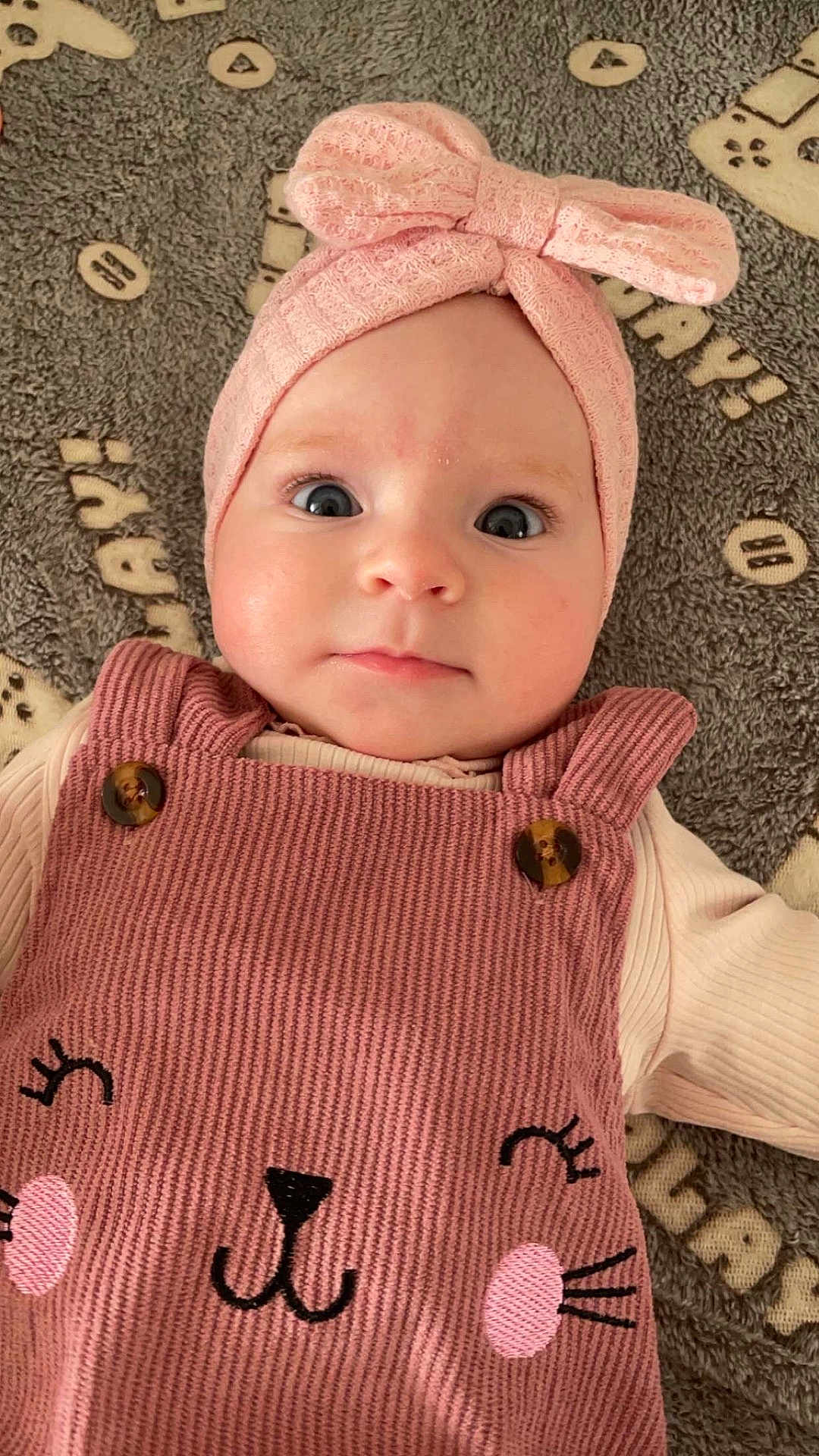 Léana a rejoint le concours — aidez-le/la à gagner de superbes lots ! baby, infant, child, pink_headband, bow, overalls, cat_face, clothing, blanket, pattern, cute, portrait, closeup, indoor, soft_lighting, face, eyes, expression, baby_girl, adorable
