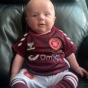 Hunter joined the competition — help win amazing prizes! baby, infant, child, sportswear, maroon, white, socks, couch, leather, smile, portrait, sitting, cute, young, face, clothing, indoor, person, apparel, happy