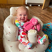 Aria joined the competition — help win amazing prizes! baby, infant, smiling, colorful_clothing, stuffed_animal, pink_bunny, inflatable_chair, wooden_floor, blanket, owl_pattern, happy, indoor, child, cute, plush_toy, sitting, face, head, person, footwear