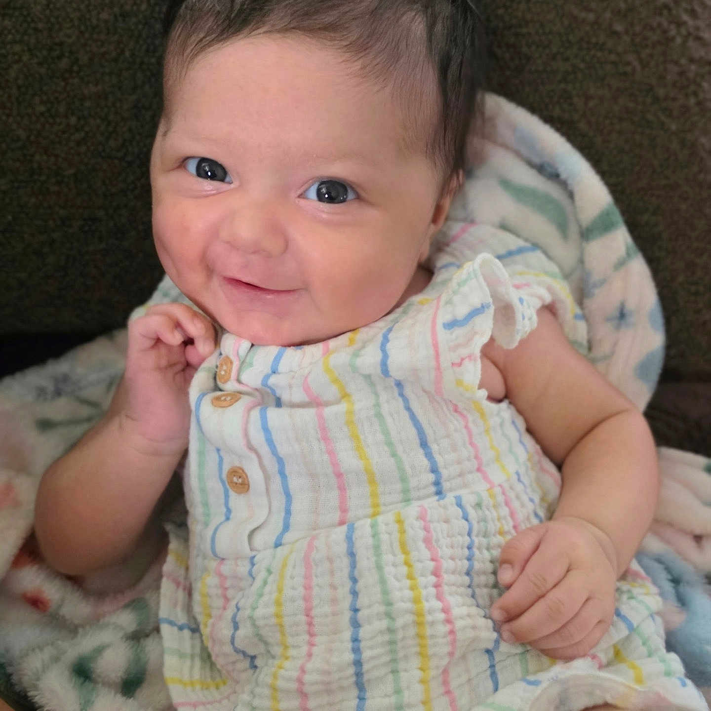 Annaleigh is registered to the contest to win money with this photo: baby, child, smiling, face, eyes, dress, striped, colorful, blanket, soft, hand, skin, cute, portrait, sitting, indoors, happy, young, infant, person
