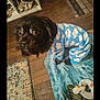Gomer joined the competition — help win amazing prizes! animal, black_dog, blanket, blue_onesie, companion, cozy, curious, cute, dog, flooring, furniture, home, indoor, looking_up, pet_clothing, plush_toy, rug, small_dog, unicorn_toy, wooden_floor