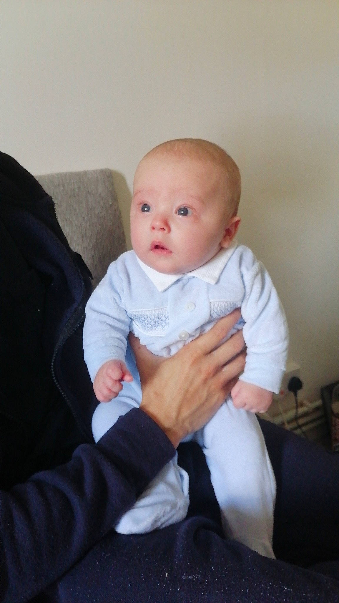 Brody is registered to the contest to win money with this photo: baby, baby_toddler_clothing, cheek, child, comfort, couch, eye, finger, flash_photography, gesture, hand, happy, iris, knee, lap, person, room, sitting, sleeve, surprise