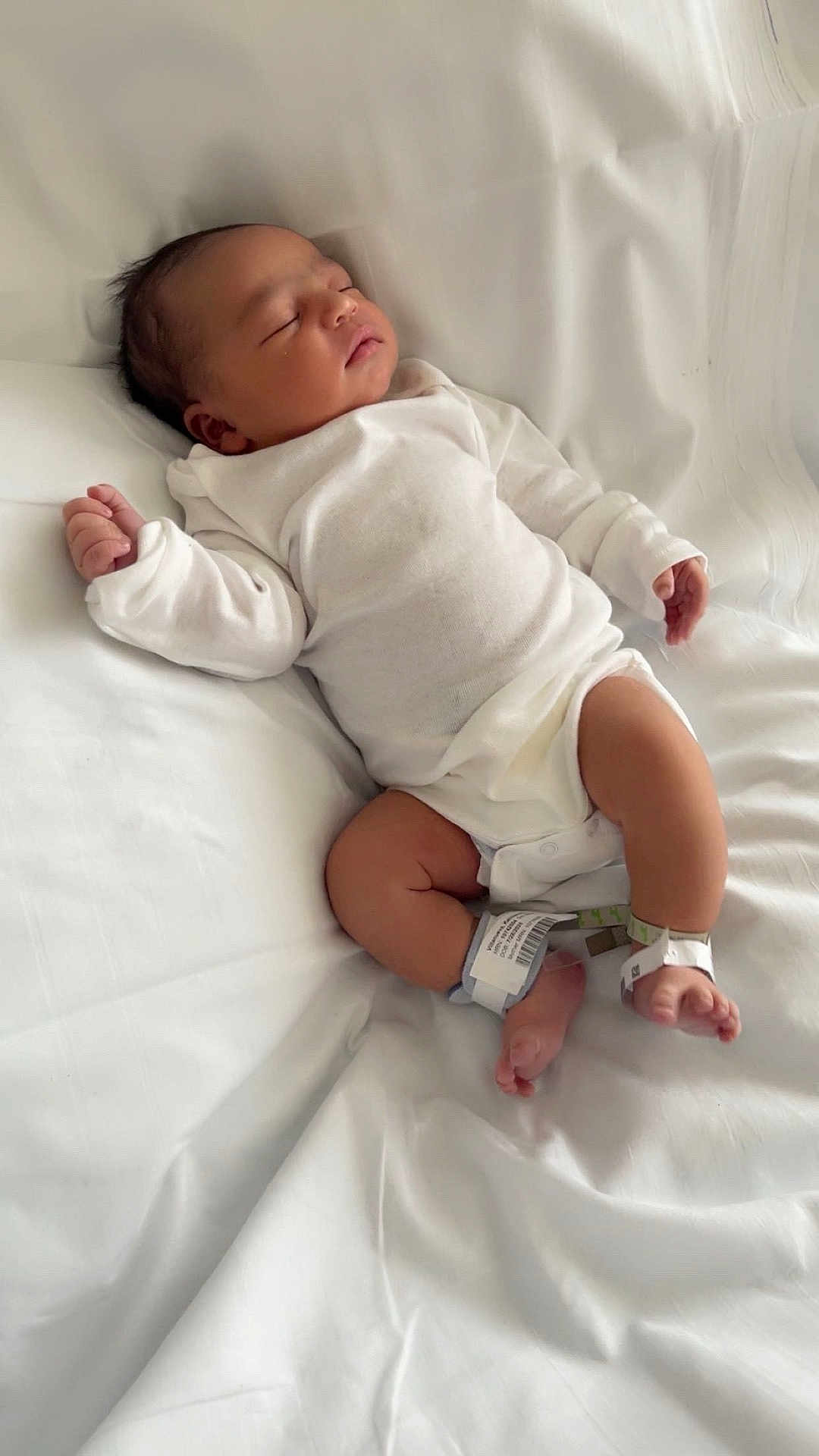 Kenny is registered to the contest to win money with this photo: newborn, baby, sleeping, white_clothing, hospital_band, blanket, infant, peaceful, lying_down, soft_light, indoors, human, skin, legs, arms, face, head, resting, cute, toddler