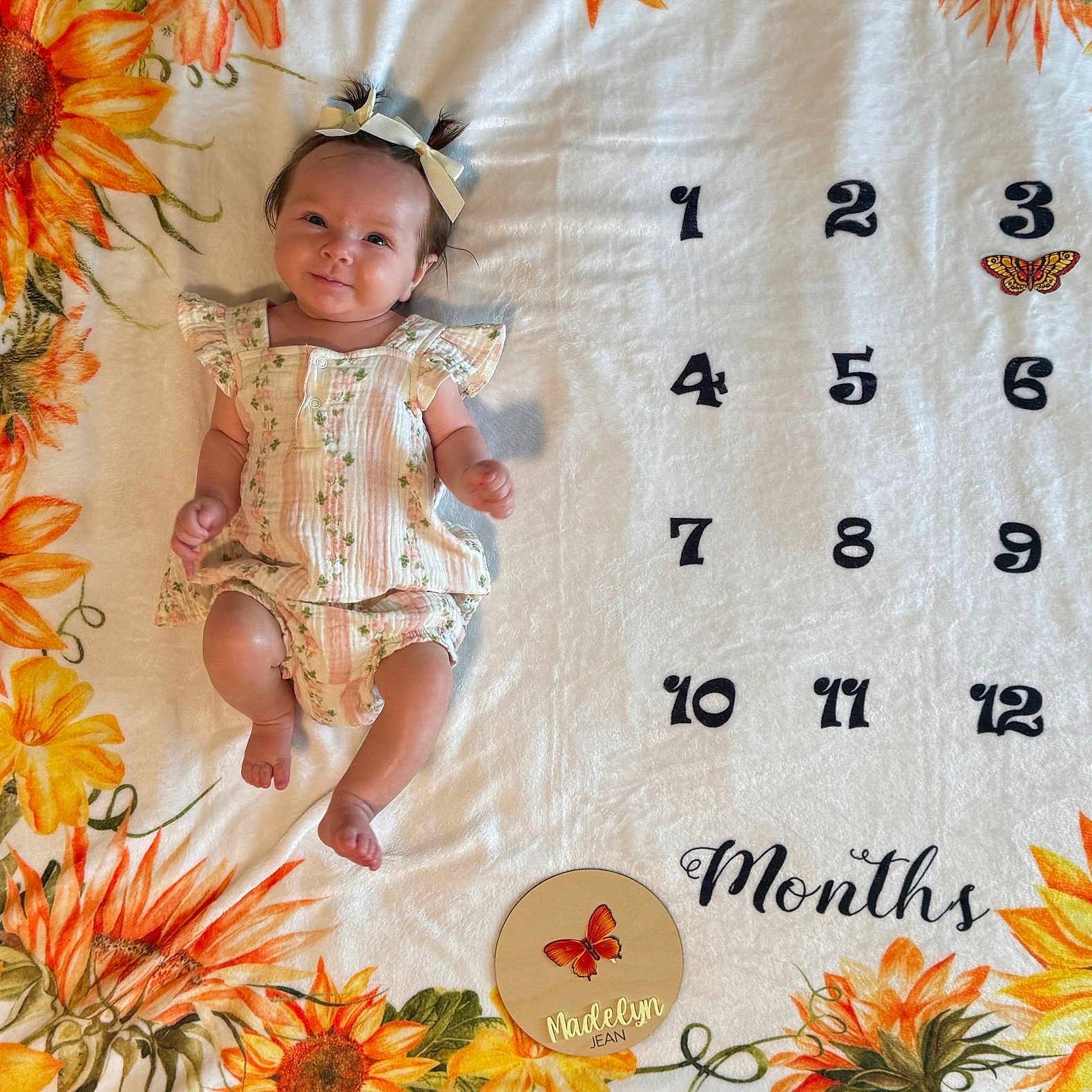 Madelyn is registered to the contest to win money with this photo: baby, blanket, bow, butterfly, child, clothing, cute, decor, flower, girl, happy, infant, laying, milestone, months, numbers, pigtails, portrait, smile, sunflower