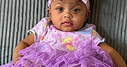 Cierra is registered to the contest to win money with this photo: baby, bow, child, clothing, couch, cute, fabric, feet, hands, happy, headband, indoors, infant, person, portrait, purple, seated, smile, texture, tutu
