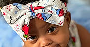Cierra is registered to the contest to win money with this photo: apparel, baby, baby_girl, background_blur, child, closeup, colorful, curly_hair, cute, expression, eyes, face, focus, headband, indoors, infant, person, portrait, skin, smile