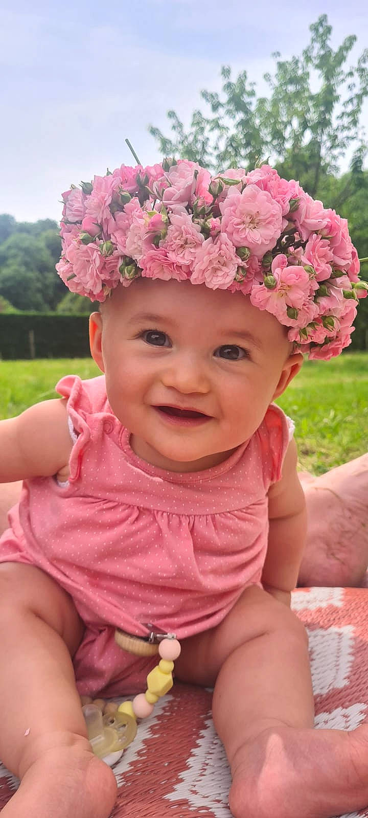 Maylis participe au concours pour gagner de l'argent avec cette photo : baby_toddler_clothing, chin, eye, facial_expression, flower, grass, green, hairstyle, happy, head, headgear, headwear, joy, lip, people_in_nature, person, photograph, pink, plant, skin