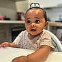 arm, baby, child, clothing, curious, cute, expression, focus, hair_loop, high_chair, indoor, infant, kitchen, person, portrait, seat, skin, table, wide_eyes, young
