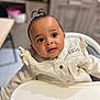 baby, buttoned_jacket, child, clothing, curious, cute, expression, eyes, face, high_chair, home, indoor, infant, looking_away, person, portrait, skin, small_pony_tail, table, young